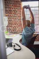 Casual businessman stretching in chair