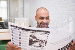 Businessman reading newspaper in office