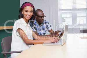 Two happy business people working together on a laptop