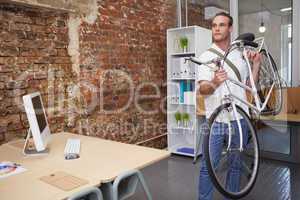 Happy businessman carrying his bicycle