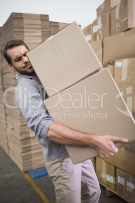 Worker carrying boxes in warehouse