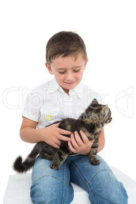 Smiling boy sitting cuddling a grey kitten