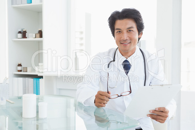 Happy doctor sitting at his desk