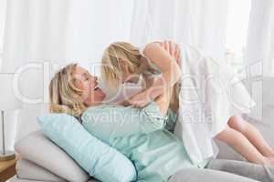 Portrait of a mother and her daughter posing on the couch