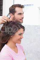 Handsome hair stylist with client
