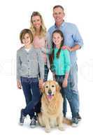 Portrait of smiling family standing together with their dog