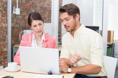 Business people working together on laptop and smiling