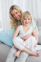 Portrait of a mother and her daughter posing on the couch