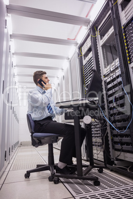 Technician talking on phone while looking servers