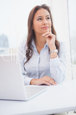 Pretty businesswoman thinking at her desk