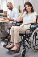 Smiling businesswoman in wheelchair on the phone