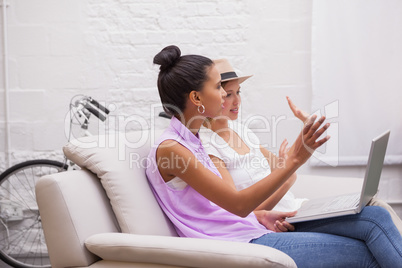 Colleagues sitting on couch working on a laptop