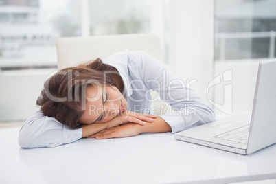 Tired businesswoman sleeping at her desk