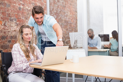 Businesswoman in wheelchair working with colleague