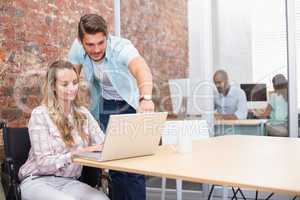 Businesswoman in wheelchair working with colleague