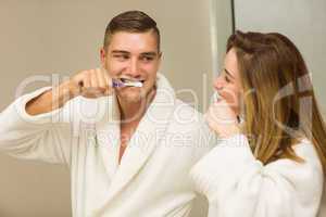 Cute couple brushing their teeth