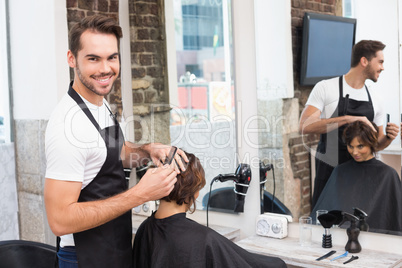 Handsome hair stylist with client