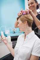 Hairdresser setting curlers in hair
