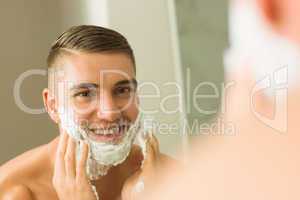 Man putting shaving foam on face