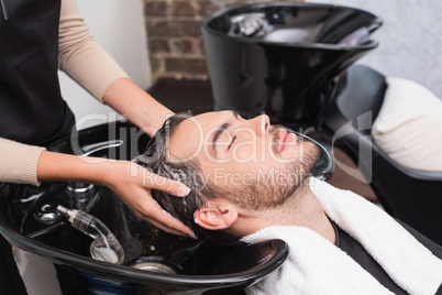 Hair stylist washing mans hair
