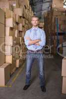 Serious manager with arms crossed in warehouse