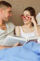 Cute couple reading book in bed