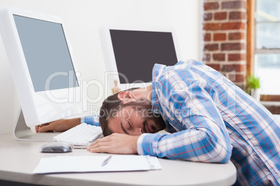 Casual businessman sleeping at his desk