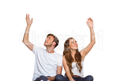 Happy young couple with hands raised