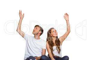 Happy young couple with hands raised