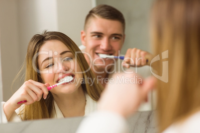 Cute couple brushing their teeth