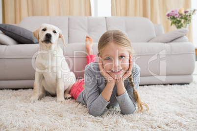 Cute little girl with her puppy on rug
