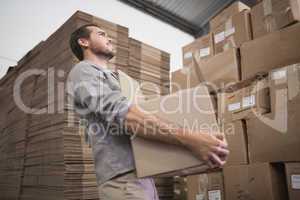 Worker carrying box in warehouse