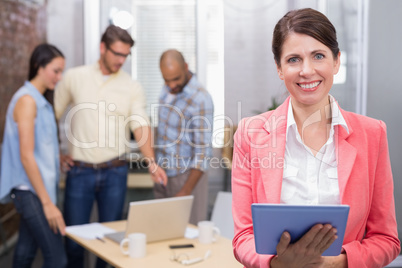 Smiling woman holding tablet in front of her colleague Smiling woman holding tablet in front of her colleague