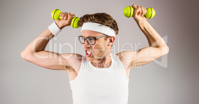 Geeky hipster posing in sportswear with dumbbells