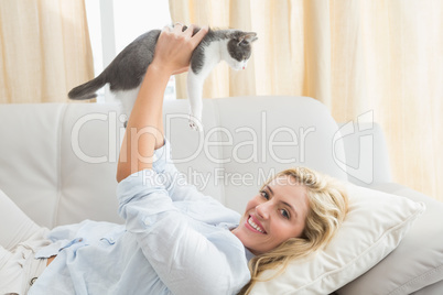 Pretty blonde with pet kitten on sofa