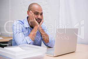 Businessman using laptop at desk