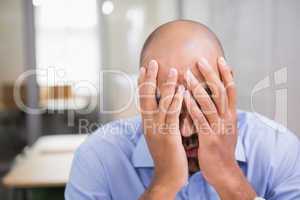 Businessman with head in hands at office