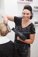 Hairdresser smiling and styling customers hair