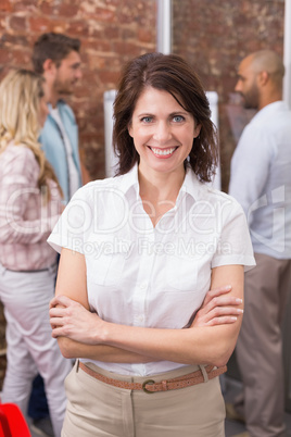 Casual businesswoman smiling at camera with arms crossed