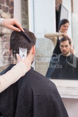 Handsome man getting his hair trimmed