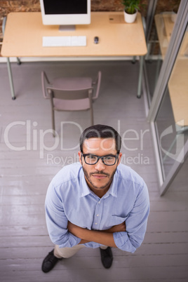 Serious businessman with arms crossed at office