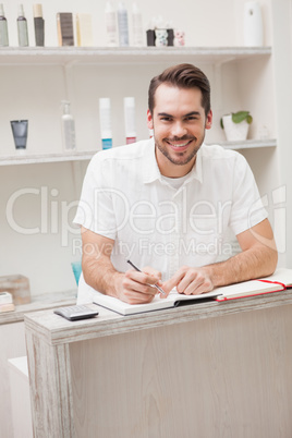 Smiling salon worker with stock book