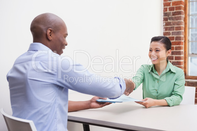 Casual business people shaking hands at desk