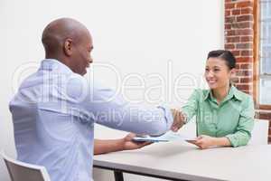 Casual business people shaking hands at desk