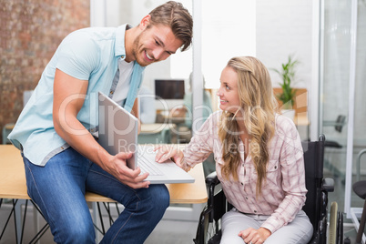 Business people smiling and working together with a laptop