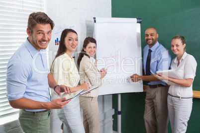 Casual business team having a meeting smiling at camera