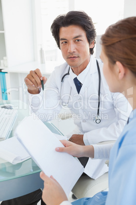 Doctor and surgeon reviewing notes