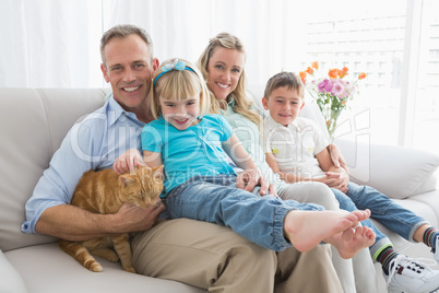 Cute family relaxing together on the couch with their cat