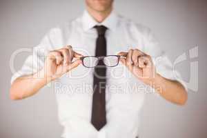 Businessman holding his reading glasses