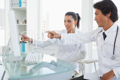 Two doctors pointing to computer screen